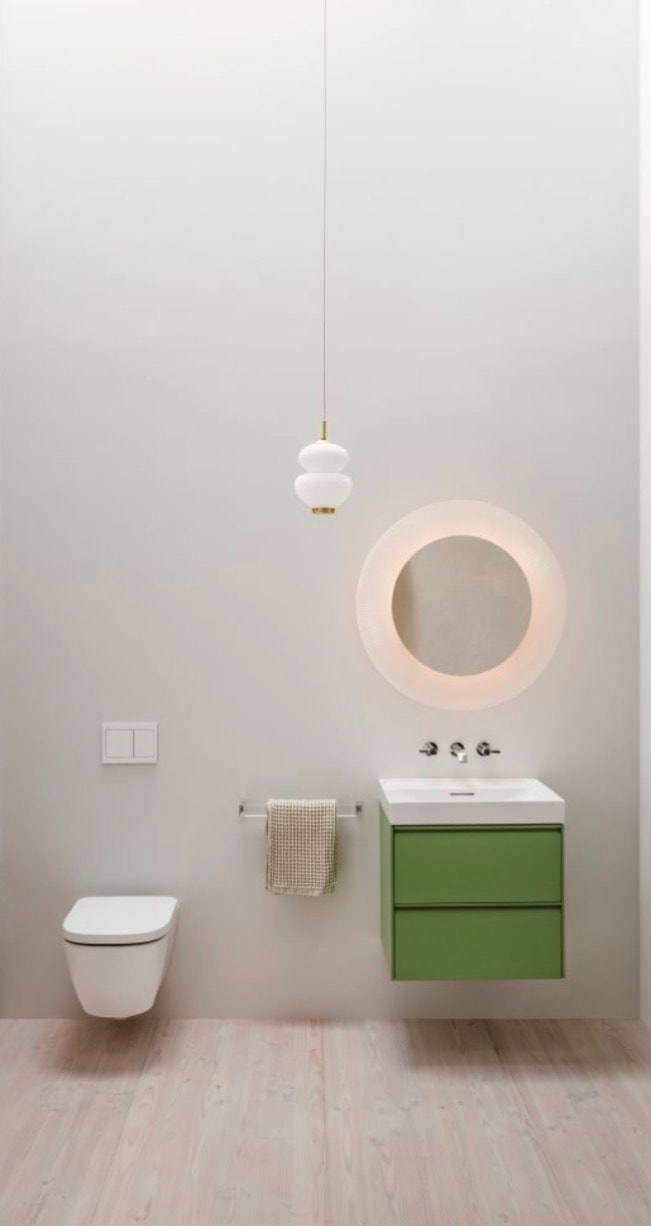 Laufen green vanity with round illuminated mirror and wall-hung toilet