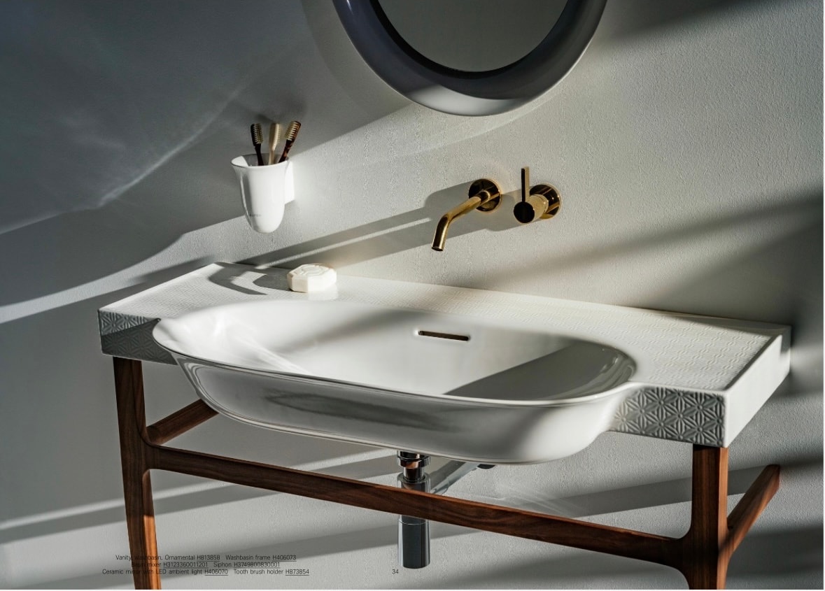 Laufen pedestal sink with round illuminated mirror on green wall
